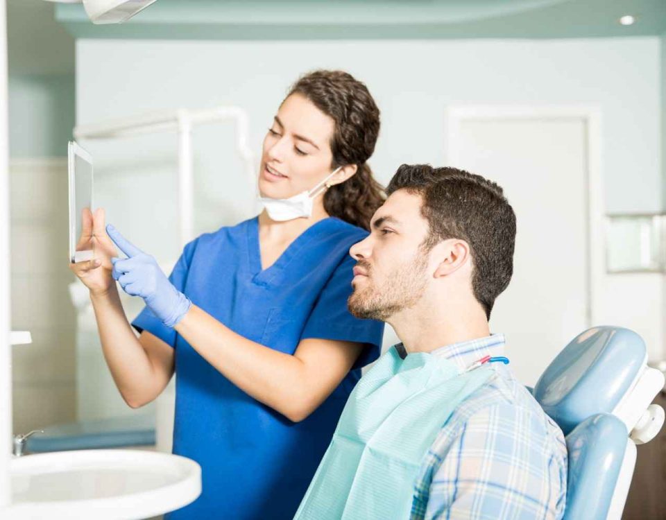 young dentist showing digital tablet male patient treatment dental clinic